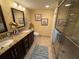 Bathroom featuring double vanity with granite countertops, tiled floor, and glass-enclosed shower at 855 Bayway Blvd # 908, Clearwater Beach, FL 33767