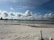 Sandy beach with calm water and skyline in the distance at 855 Bayway Blvd # 908, Clearwater Beach, FL 33767