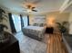 Bright bedroom featuring a ceiling fan, beach-themed artwork, and balcony access at 855 Bayway Blvd # 908, Clearwater Beach, FL 33767