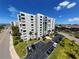 View of a modern condo building with well-maintained landscaping and convenient parking at 855 Bayway Blvd # 908, Clearwater Beach, FL 33767
