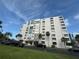 Modern condo complex featuring a well-maintained exterior, lush landscaping and ample parking at 855 Bayway Blvd # 908, Clearwater Beach, FL 33767