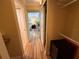 Hallway with wood flooring and an open view into a bedroom with natural light and calming blue decor at 855 Bayway Blvd # 908, Clearwater Beach, FL 33767