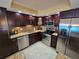 Updated kitchen with stainless appliances, stone countertops, and dark wood cabinets, under recessed lighting at 855 Bayway Blvd # 908, Clearwater Beach, FL 33767