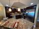 Updated kitchen features stainless appliances, granite countertops, dark cabinetry, and pendant lighting at 855 Bayway Blvd # 908, Clearwater Beach, FL 33767