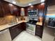 Modern kitchen features stainless appliances, granite countertops, wood cabinetry, and recessed lighting at 855 Bayway Blvd # 908, Clearwater Beach, FL 33767