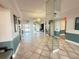Bright lobby area with tile flooring, mirrored walls, fresh paint, and view of front doors with natural light at 855 Bayway Blvd # 908, Clearwater Beach, FL 33767