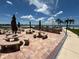 Outdoor kitchen and seating area with multiple tables, chairs, and charcoal grills at 855 Bayway Blvd # 908, Clearwater Beach, FL 33767