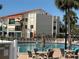 Outdoor pool area featuring lounge chairs, tables, and shaded umbrellas at 855 Bayway Blvd # 908, Clearwater Beach, FL 33767