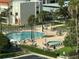 Aerial view of large community pool with lounge chairs and palm trees at 855 Bayway Blvd # 908, Clearwater Beach, FL 33767