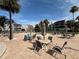 Community pool surrounded by tables, chairs, and lounge chairs with palm trees and red-roofed condos at 855 Bayway Blvd # 908, Clearwater Beach, FL 33767