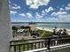 Balcony view showcasing sandy beaches, serene ocean waters, city buildings, and a bright cloudy sky at 855 Bayway Blvd # 908, Clearwater Beach, FL 33767