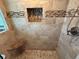 A beige tiled shower features a built in seat, soap niche and horizontally striped accent tiles at 855 Bayway Blvd # 908, Clearwater Beach, FL 33767