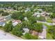 An aerial view showcasing a neighborhood surrounded by mature trees close to shops and amenities at 878 Franklin Cir, Palm Harbor, FL 34683