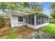 Charming backyard featuring a screened-in porch, offering a perfect outdoor space for relaxation at 878 Franklin Cir, Palm Harbor, FL 34683