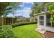 Cozy backyard featuring a lawn, partial fence, and small enclosed Florida room at 878 Franklin Cir, Palm Harbor, FL 34683