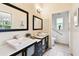 Well-lit bathroom featuring dual vanities, modern fixtures, and tile floors at 878 Franklin Cir, Palm Harbor, FL 34683