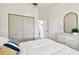 Bedroom with white dresser with mirror, queen bed with white linens, and closet at 878 Franklin Cir, Palm Harbor, FL 34683