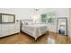 Bright bedroom featuring wood floors, a large window, and a comfortable bed with neutral decor at 878 Franklin Cir, Palm Harbor, FL 34683