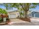 Charming single-story home featuring a one car garage, mature landscaping, and a welcoming front entrance at 878 Franklin Cir, Palm Harbor, FL 34683