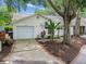 Inviting single-story home featuring a private driveway, lush landscaping, and a charming curb appeal at 878 Franklin Cir, Palm Harbor, FL 34683