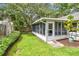 View of Florida room featuring screens, a door to the backyard, and tropical landscaping at 878 Franklin Cir, Palm Harbor, FL 34683