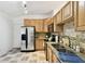 Functional kitchen features wood cabinets, granite countertops, and stainless steel appliances at 878 Franklin Cir, Palm Harbor, FL 34683