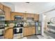 Bright kitchen with stainless steel appliances, wooden cabinetry and tile backsplash at 878 Franklin Cir, Palm Harbor, FL 34683