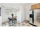 Kitchen eating area with stainless fridge, table, chairs, and ample sunlight at 878 Franklin Cir, Palm Harbor, FL 34683