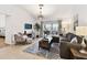 Bright living room with stylish decor, comfortable seating, and sliding door to the outdoor space at 878 Franklin Cir, Palm Harbor, FL 34683