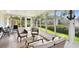Bright sunroom with tile flooring, neutral colored seating and view of the backyard at 878 Franklin Cir, Palm Harbor, FL 34683