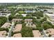 Aerial view showcases lush landscaping, a tranquil pond, and residences with private parking at 897 Lantern Way, Clearwater, FL 33765