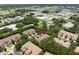 This aerial shot shows the beautiful townhome complex near commercial properties in a lush, wooded setting at 897 Lantern Way, Clearwater, FL 33765