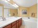 Bright bathroom with double sinks, a bathtub, and a separate glass door shower at 897 Lantern Way, Clearwater, FL 33765