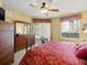 Bedroom boasts a ceiling fan, a wooden dresser with mirror, and a window overlooking the outdoor landscape at 897 Lantern Way, Clearwater, FL 33765