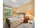 Charming bedroom with a large window, a wooden bed, and two comfortable chairs at 897 Lantern Way, Clearwater, FL 33765