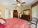 Bright bedroom with a ceiling fan, two dressers, and an ornate chair at 897 Lantern Way, Clearwater, FL 33765