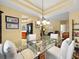 Open dining area with a glass-top table, bright lighting, and views into the kitchen and living areas at 897 Lantern Way, Clearwater, FL 33765