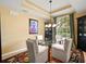 Bright dining room boasts a glass-top table, comfortable seating, and decorative chandelier fixture at 897 Lantern Way, Clearwater, FL 33765