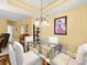 Bright dining room features a glass-top table, white chairs, and decorative chandelier lighting at 897 Lantern Way, Clearwater, FL 33765