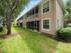 A well-maintained exterior view of the home with a manicured lawn and screened in porch at 897 Lantern Way, Clearwater, FL 33765