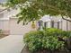 Charming townhome with a private garage adorned with a wreath and lush landscaping at 897 Lantern Way, Clearwater, FL 33765