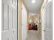 Hallway with white doors leading to a bedroom featuring a decorated bed and side table at 897 Lantern Way, Clearwater, FL 33765