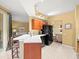 Open concept kitchen with bar seating and black refrigerator, leading into the living area at 897 Lantern Way, Clearwater, FL 33765