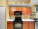 A kitchen featuring wood cabinets, white countertops, and modern black appliances at 897 Lantern Way, Clearwater, FL 33765
