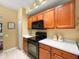 A well-lit kitchen with wooden cabinets, a black oven, and light countertops at 897 Lantern Way, Clearwater, FL 33765
