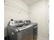 Efficient laundry room equipped with modern washer and dryer set and a wire shelf at 897 Lantern Way, Clearwater, FL 33765