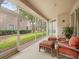 Relaxing screened-in porch with comfortable seating and tranquil views of the lush green lawn at 897 Lantern Way, Clearwater, FL 33765