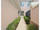 Exterior walkway bordered by manicured shrubs leading to the home's entrance at 897 Lantern Way, Clearwater, FL 33765