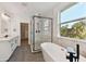 A modern bathroom with a glass-enclosed shower, soaking tub, and stylish vanity at 905 N Willow Ave, Tampa, FL 33606