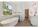 Bright bathroom boasts a freestanding tub, walk-in closet and marble accents, perfect for relaxation at 905 N Willow Ave, Tampa, FL 33606